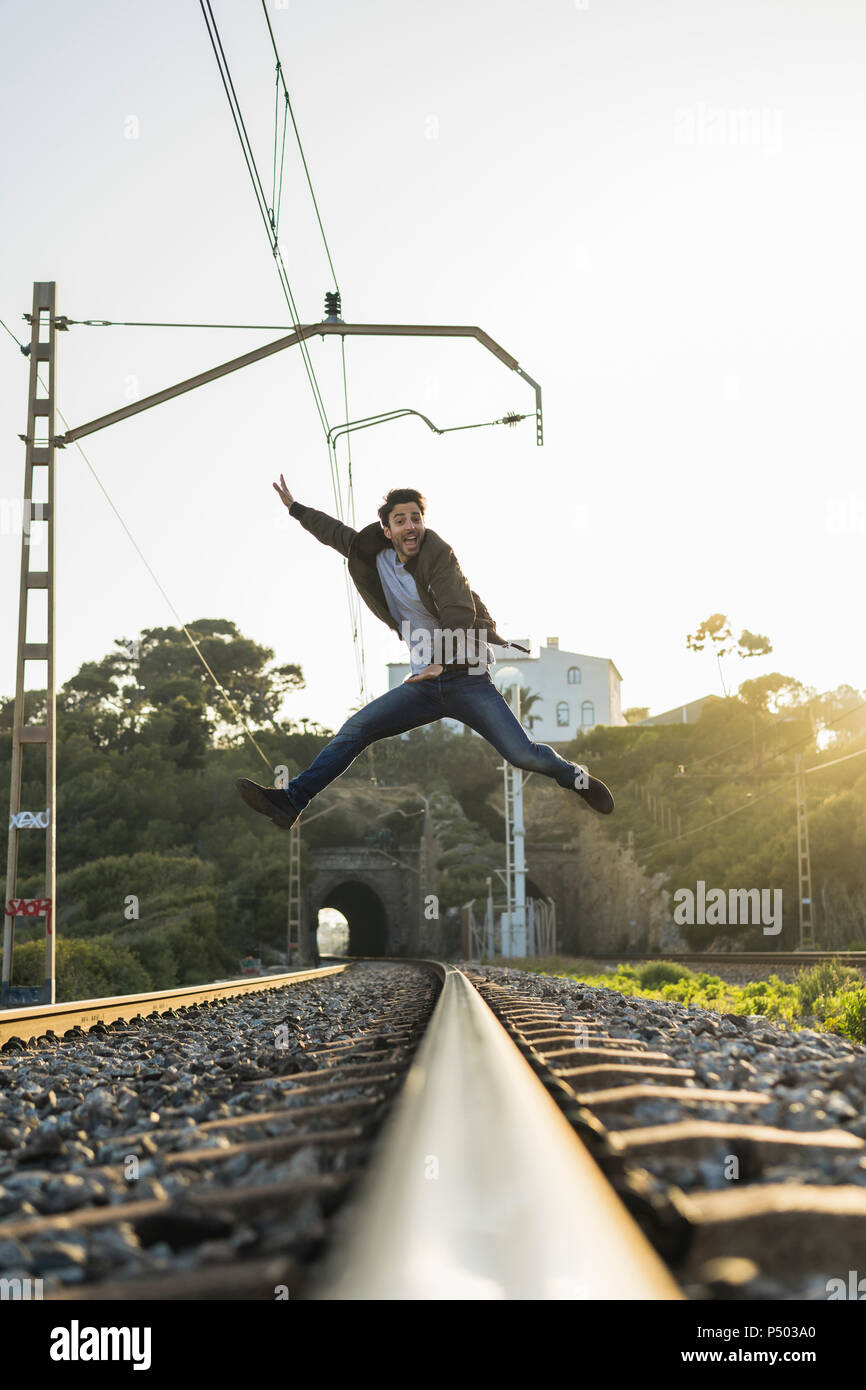 Giovane uomo saltare in aria, ferrovia via Foto Stock