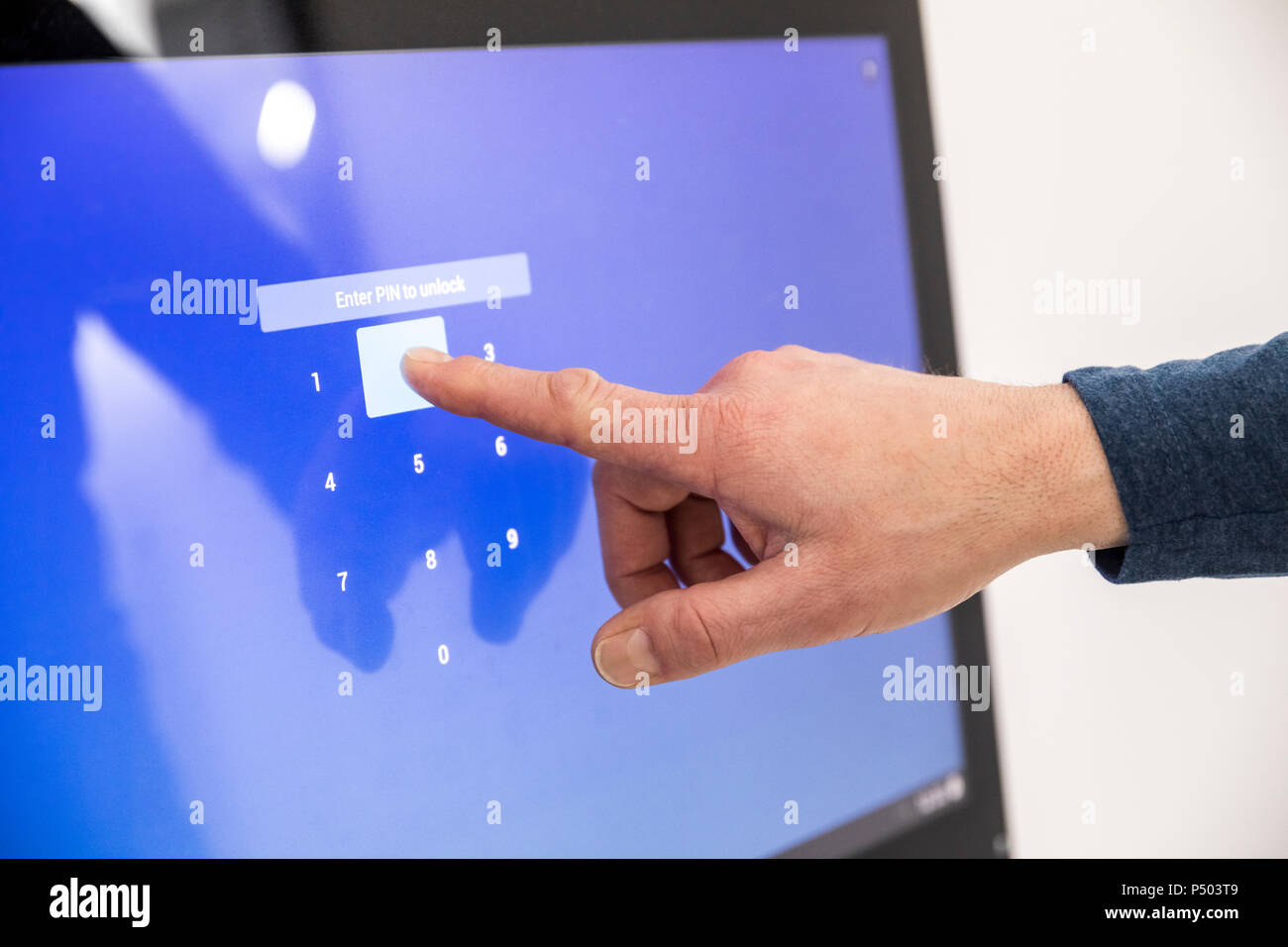 Imprenditore immettendo il codice PIN sul touch screen Foto Stock