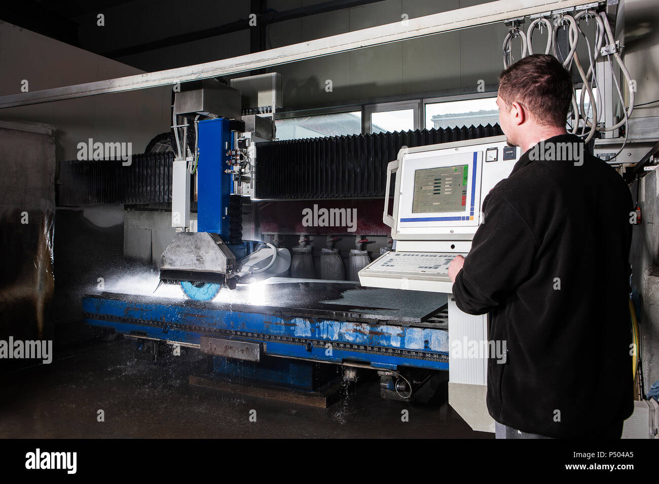 Scalpellino lavorando con macchine CNC nel suo laboratorio Foto Stock