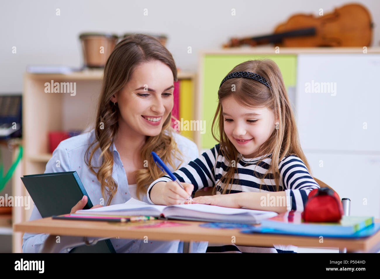 Maestro sorridente con schoolgirl in classe Foto Stock