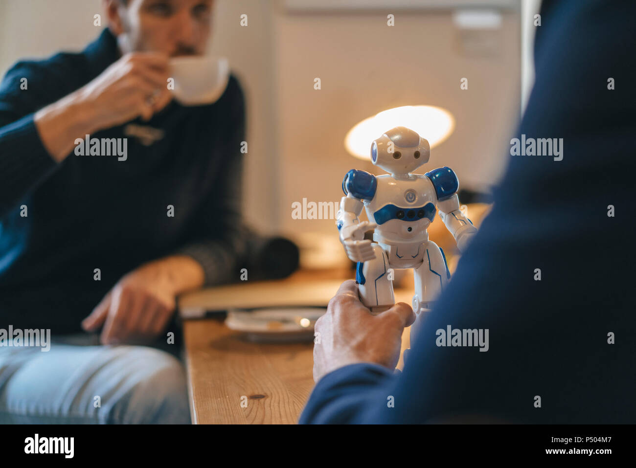 Due uomini e robot sulla tabella Foto Stock