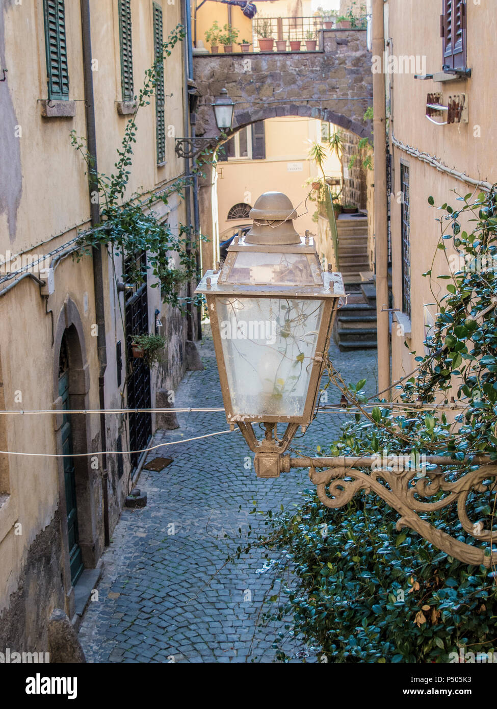 Lampione in un caratteristico vicolo di Tuscania, città medievale nei pressi di Roma (Italia) Foto Stock