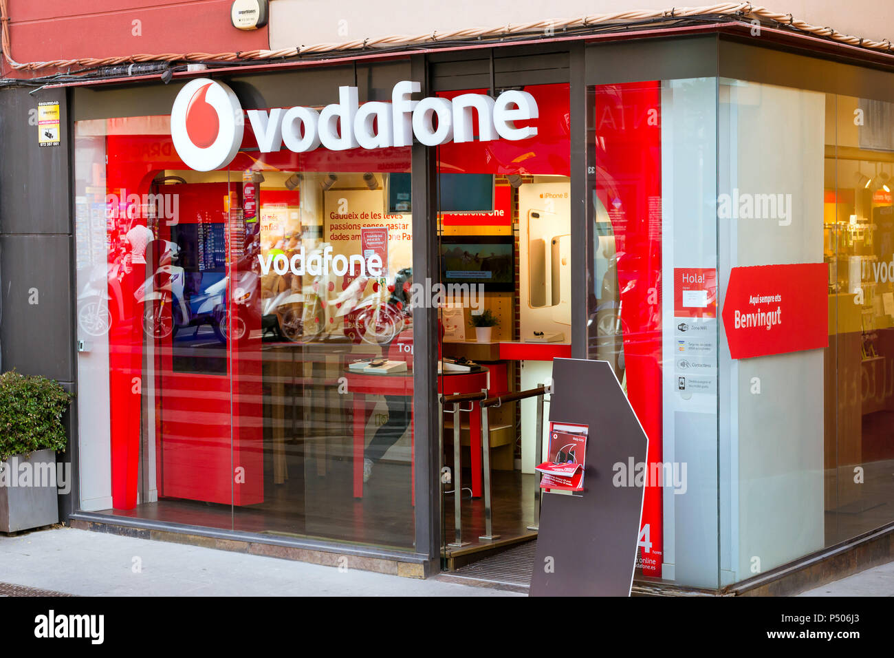 Cartello di società di telecomunicazioni Vodafone sulla parete di vetro di edificio nel centro della città. Lo spagnolo beach resort Blanes, Costa Brava, la Catalogna Foto Stock