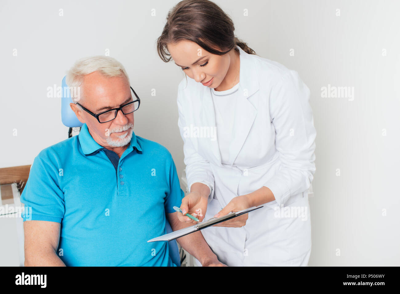 Medico e paziente senior riesame grafico medici Foto Stock