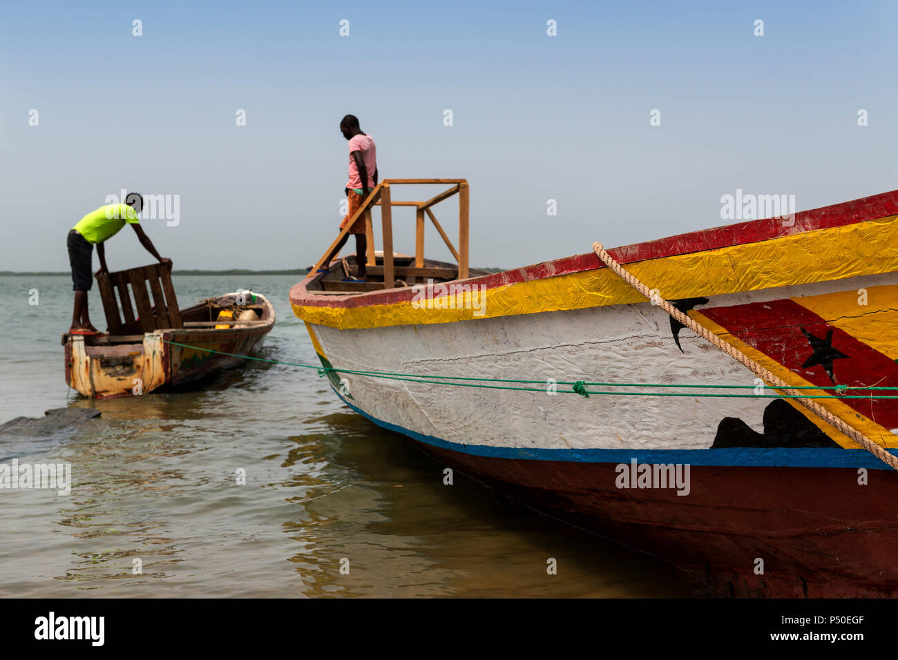 Cacheu, Repubblica di Guinea Bissau - 1 Febbraio 2018: i pescatori preparano le loro canoe nel porto della città di Cacheu in Guinea Bissau. Foto Stock