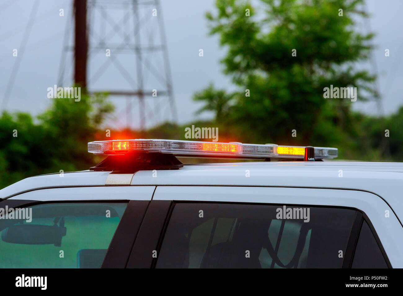 Luce blu lampeggiante sulla vista closeup top della polizia auto, sfocatura  paesaggio urbano sfondo. La barra luminosa e sirena montata sul tetto,  veicolo di emergenza, polizia comunale Foto stock - Alamy