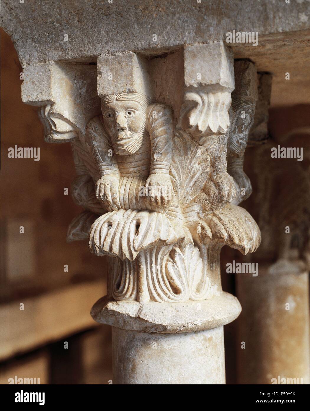 Spagna. Girona. Abbazia di San Pietro di Galligants. Chiostro. Romanico. Xii secolo. Capitale raffigurante un uomo in appoggio le mani sulle sue ginocchia. Foto Stock