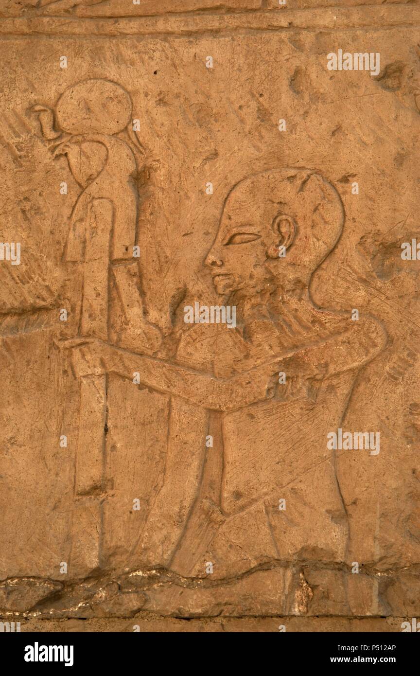 Arte Egizia. Rilievo raffigurante un sacerdote che porta l'immagine del Dio Ra (disco solare). Tempio di Hatshepsut, regina del XVIII dinastia. Nuovo Regno. Deir el-Bahari. Luxor. Antica Tebe (Waset). Foto Stock