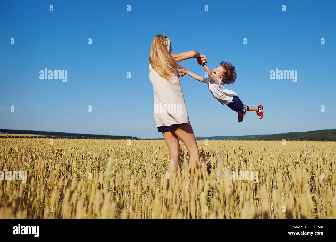La madre si trasforma un bambino divertirsi sulla natura dell'estate. Foto Stock