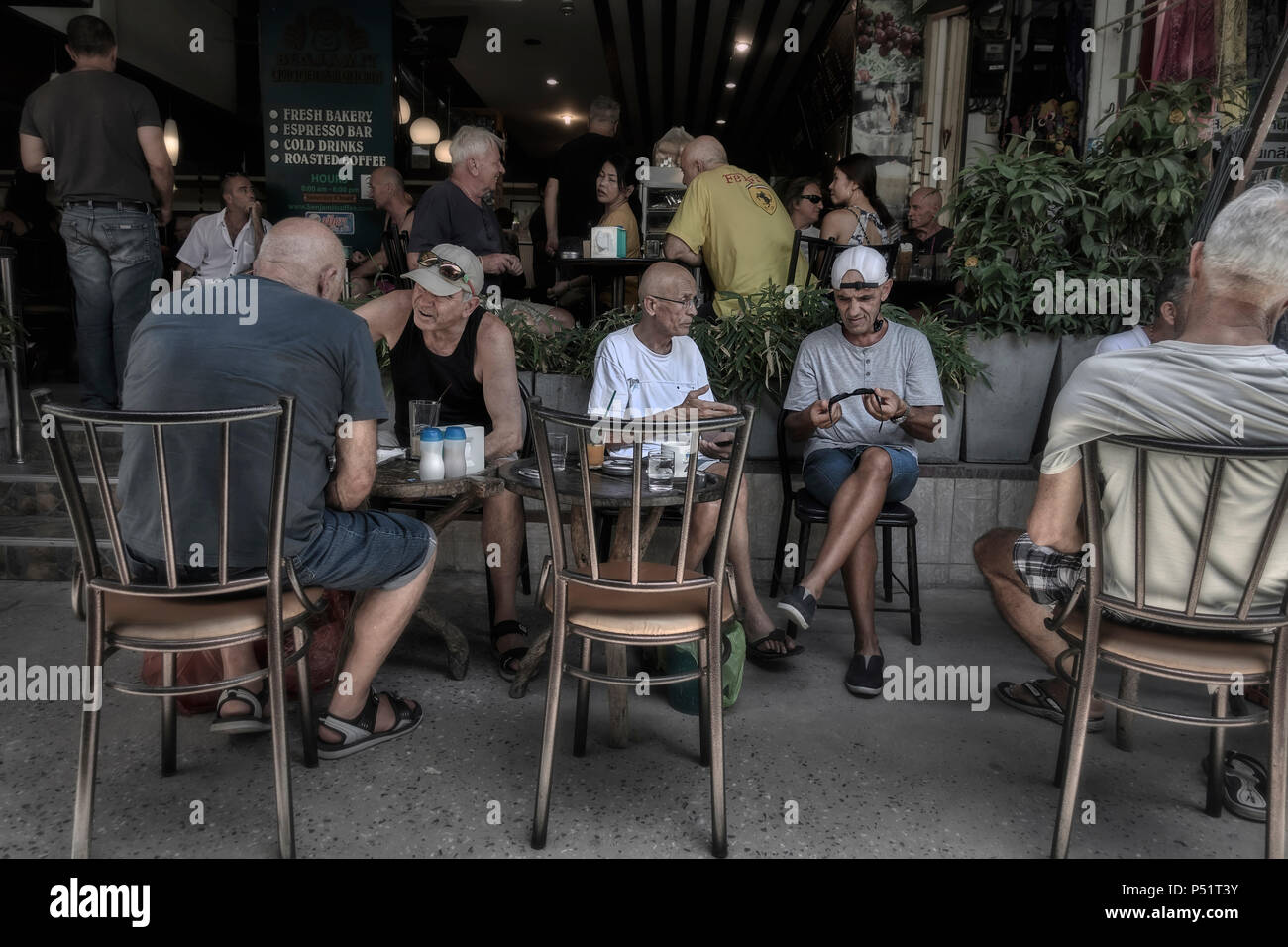 Passando il tempo del giorno. Le persone a un cafe' sul marciapiede Foto Stock
