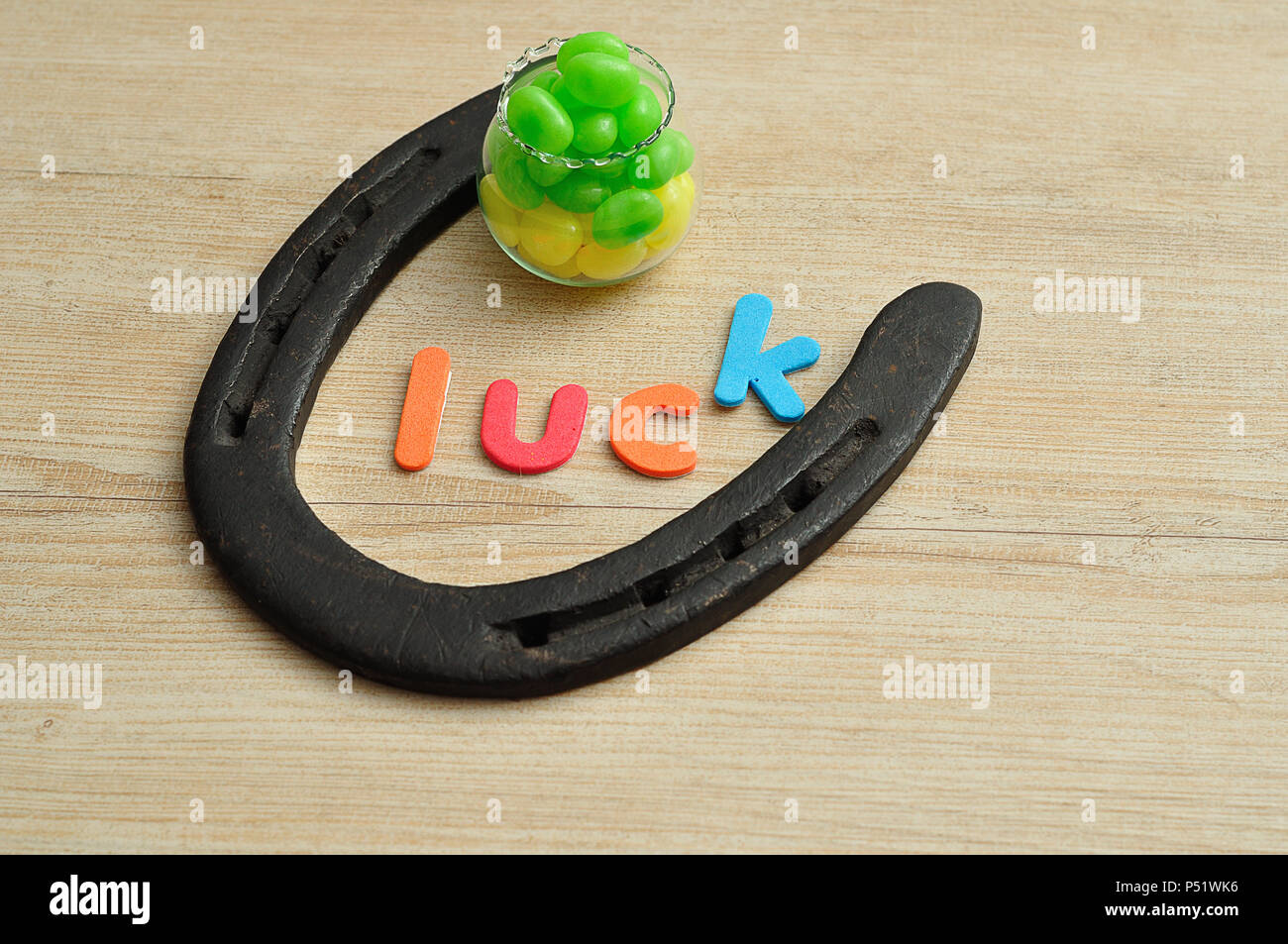La parola fortuna con un ferro di cavallo e una pentola con il verde e il giallo jellybeans Foto Stock