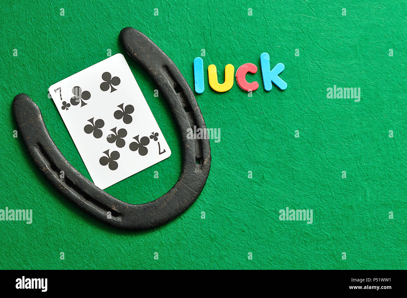 La parola fortuna visualizzata con una carta da gioco 7 di trifogli e un ferro di cavallo per Saint Patricks giorno Foto Stock