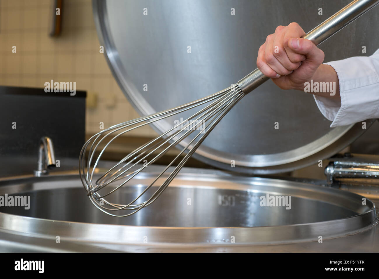 Mescolare con una frusta in una grande cucina Foto Stock