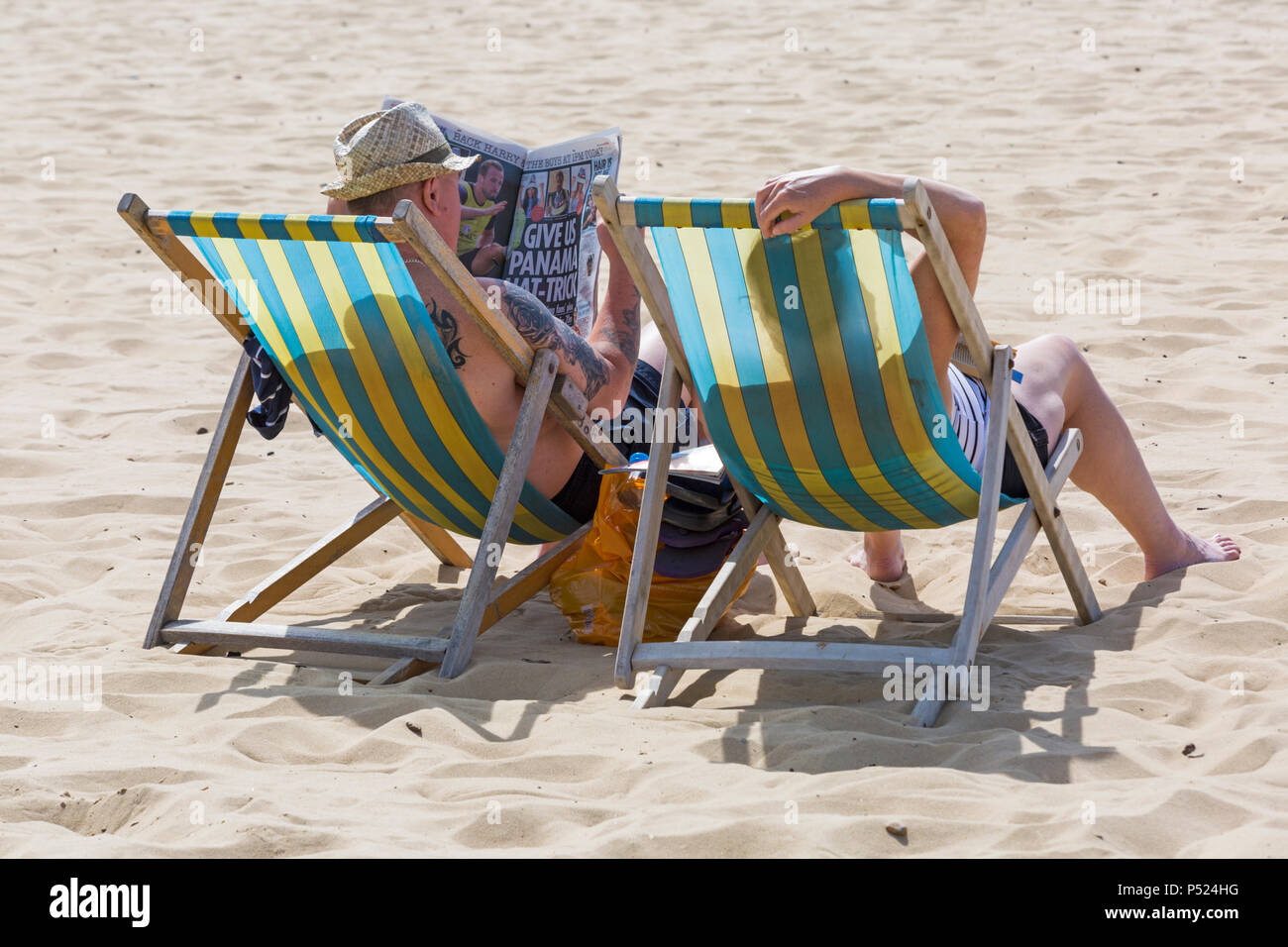 Bournemouth Dorset, Regno Unito. Il 24 giugno 2018. Regno Unito meteo: la mattina presto e già le spiagge sono di riempimento e parcheggi per ottenere il pieno, su un altro bel calda giornata soleggiata come testa di visitatori al mare per rendere la maggior parte del sole Come temperature aumento per l'ondata di caldo. Recupero con le notizie seduto nella sedia a sdraio. Credito: Carolyn Jenkins/Alamy Live News Foto Stock