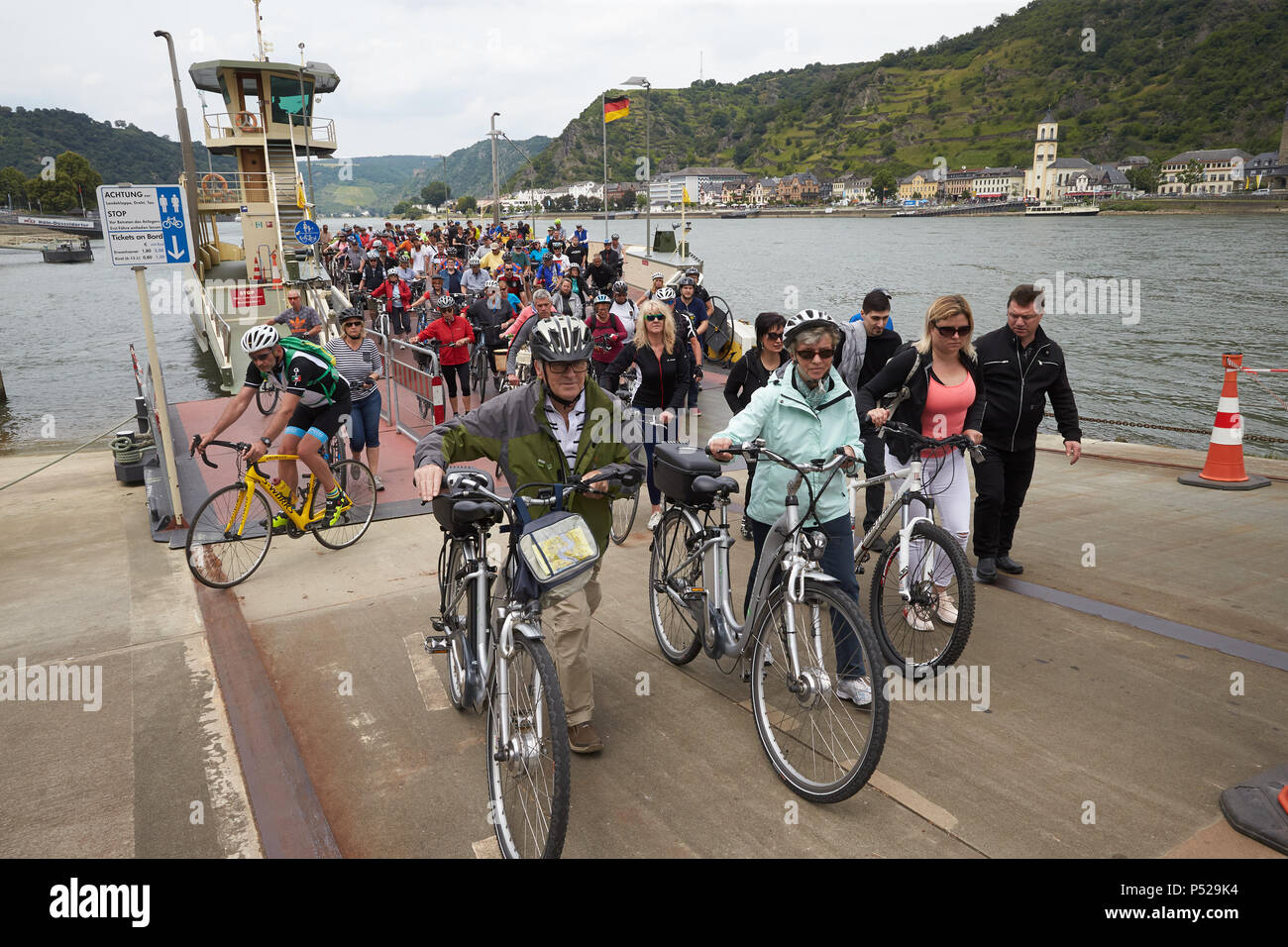 24 giugno 2018, St. Goar, Germania: I ciclisti lasciare il Rheinfähre in St. Goar presso l'auto-free ciclismo giornata 'Tal totale". L Ufficio federale delle strade lungo il Reno tra Lahnstein e Kaub e Coblenza e Bingen sono chiusi tutto il giorno per il traffico motorizzato. Foto: Thomas Frey/dpa Credito: dpa picture alliance/Alamy Live News Foto Stock