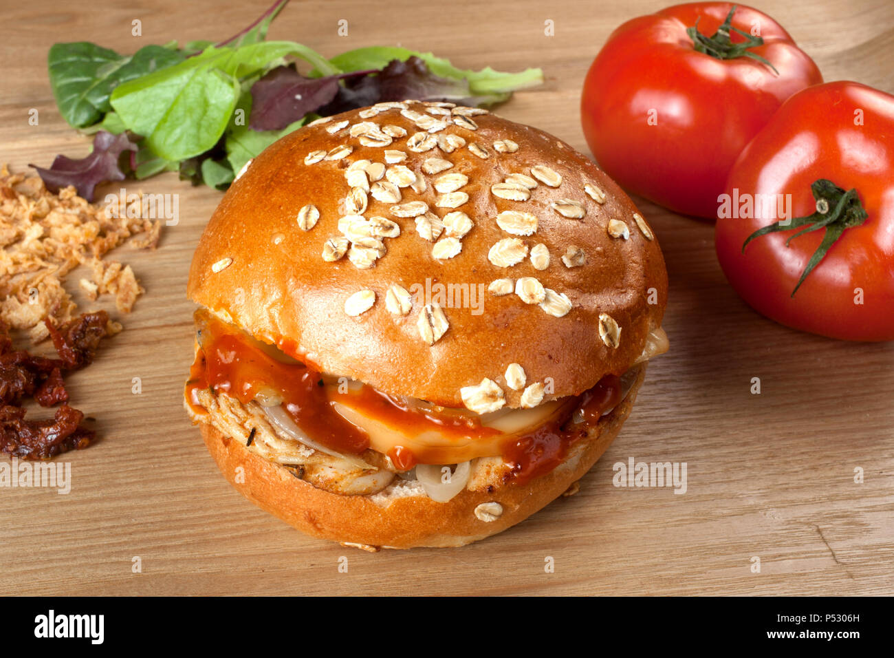 Hamburger fatti in casa con diversi formaggio e cipolle fritte su un tavolo di legno Foto Stock