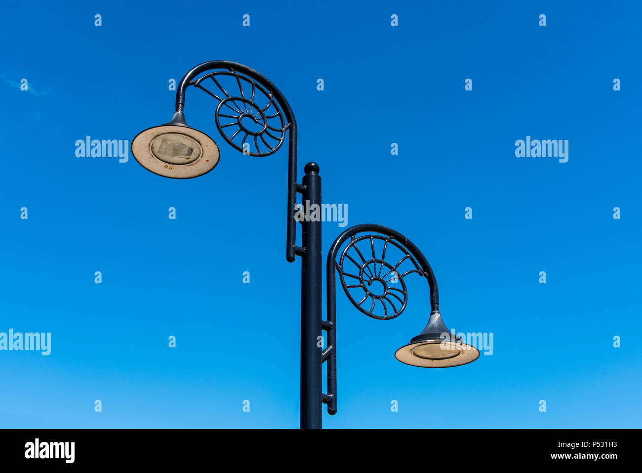 LYME REGIS, DORSET, Regno Unito, 14giu2018: Lampade sul lungomare di Lyme hanno un design ammonita per riconoscere la città la sua associazione con i fossili. Foto Stock