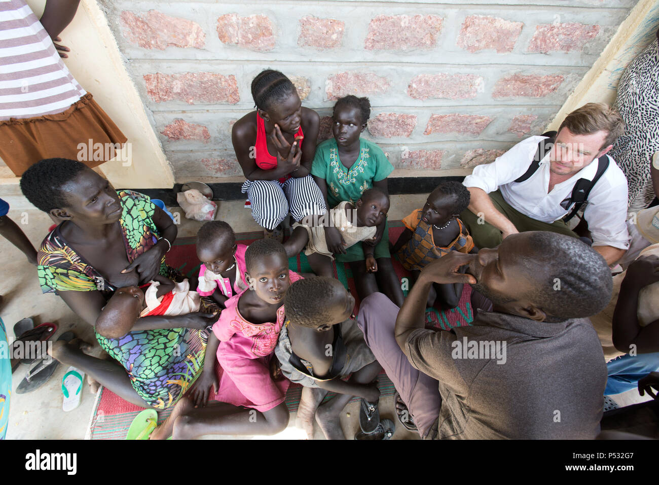 Kakuma, Kenya - Kai Feldhaus, giornalista del quotidiano Bild in conversazione con i nuovi arrivati nel centro di registrazione di Kakuma. Foto Stock