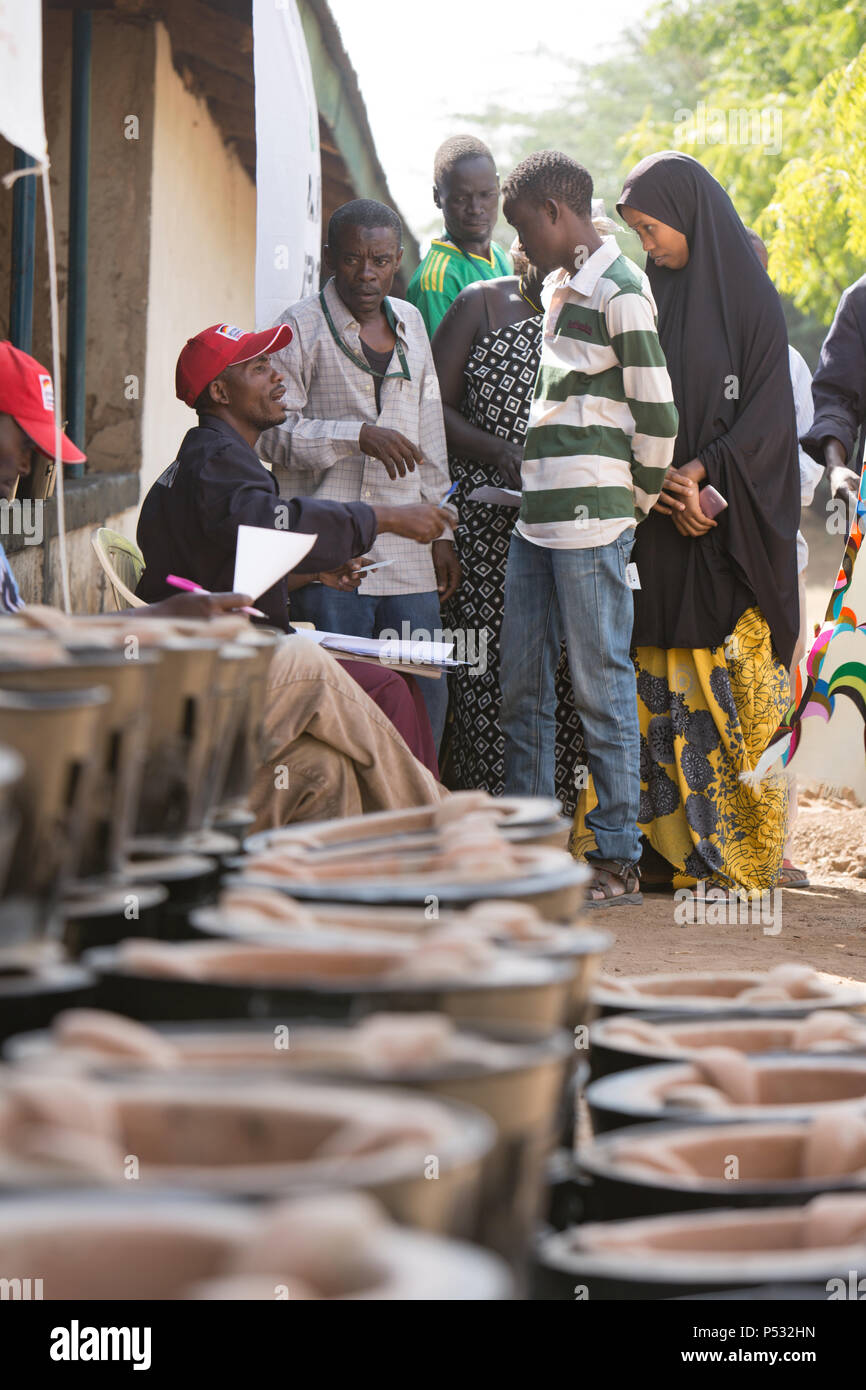 Kakuma, Kenya - nel campo di rifugiati di Kakuma, un dipendente locale distribuisce i forni di cottura per i giovani rifugiati. Foto Stock