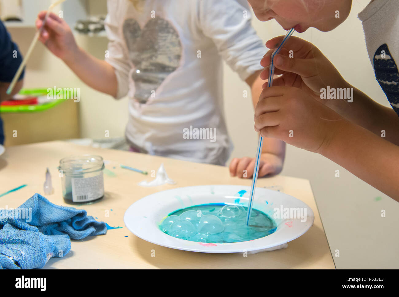 Bambini che giocano con i colori del fluido in un asilo nido Foto Stock