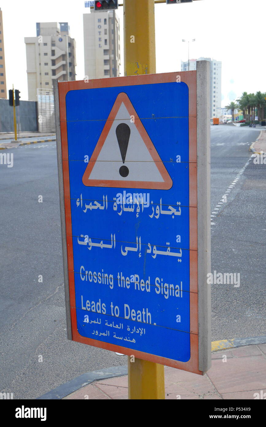 Cartello stradale in inglese e in arabo in Kuwait City, attraversando il segnale rosso conduce alla morte. Foto Stock