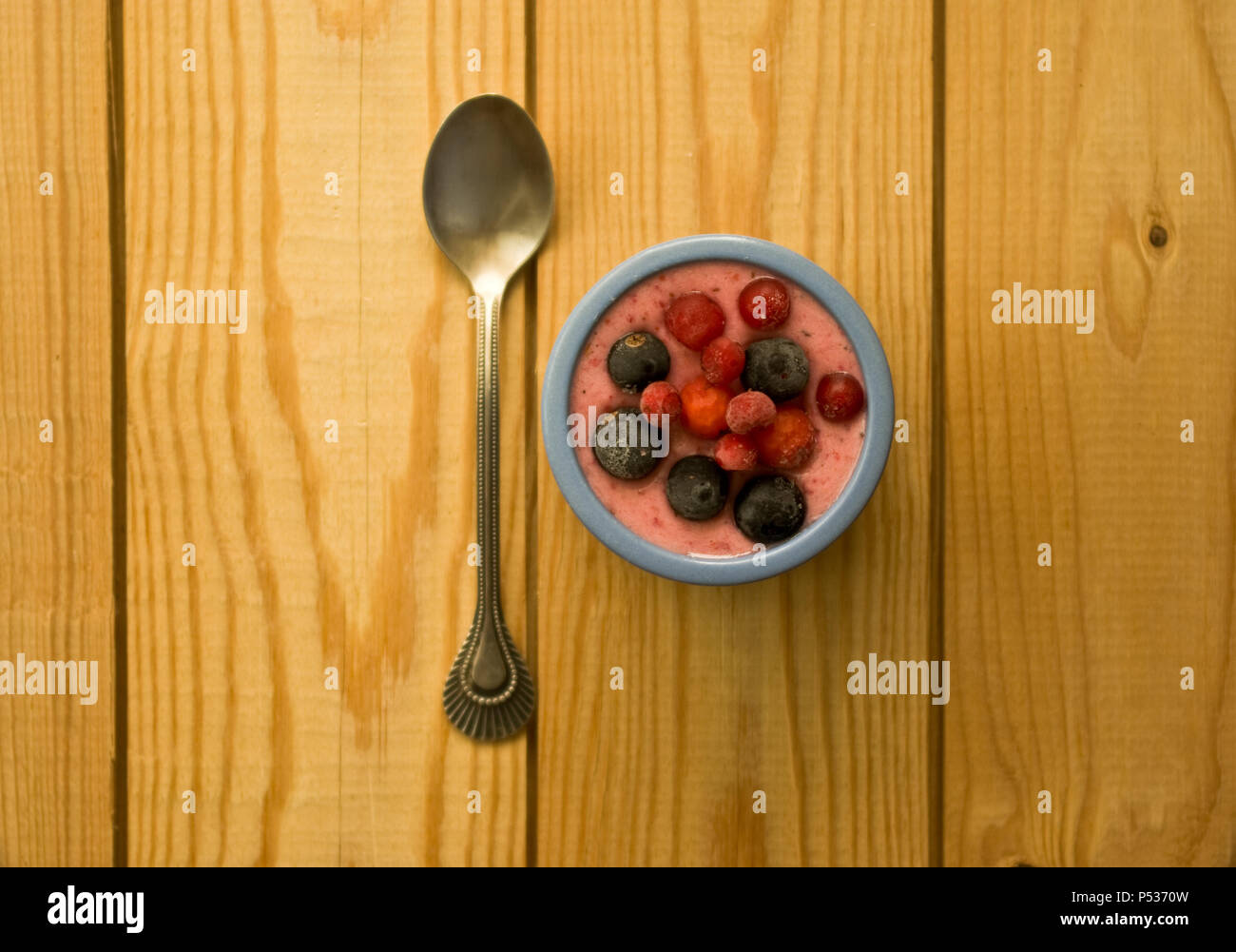 Rosa di yogurt con la foresta di frutti di bosco surgelati sulla sommità. flat laici. Foto Stock