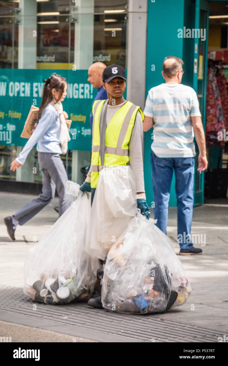 Una donna di raccolta sotto forma di lettiera cestini nel centro della città di Birmingham, Birmingham, Inghilterra, Regno Unito Foto Stock