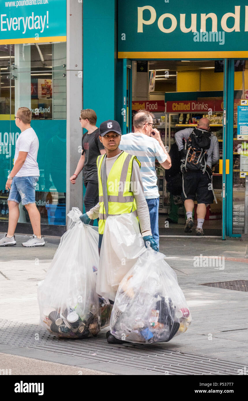 Una donna di raccolta sotto forma di lettiera cestini nel centro della città di Birmingham, Birmingham, Inghilterra, Regno Unito Foto Stock