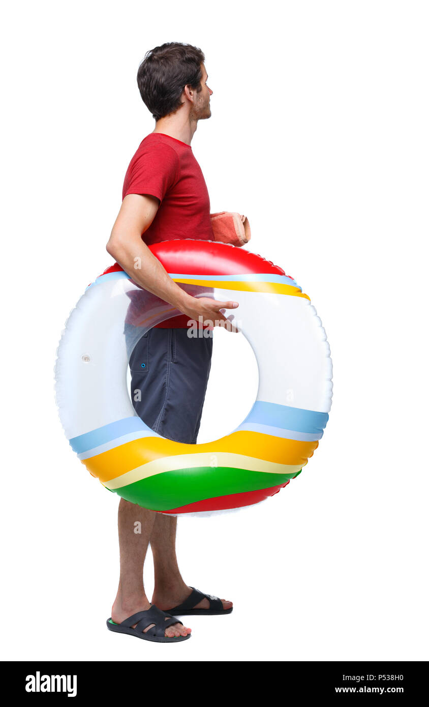 Vista posteriore di un uomo in pantaloncini corti con un cerchio gonfiabile. Il ragazzo sulla spiaggia. Vista posteriore di raccolta persone. vista posteriore di persona. Isolate su wh Foto Stock