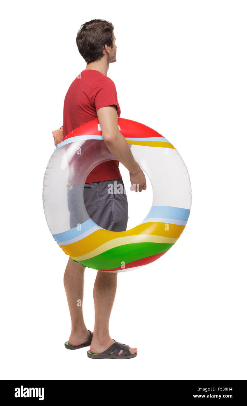 Vista posteriore di un uomo in pantaloncini corti con un cerchio gonfiabile. Il ragazzo sulla spiaggia. Vista posteriore di raccolta persone. vista posteriore di persona. Isolate su wh Foto Stock