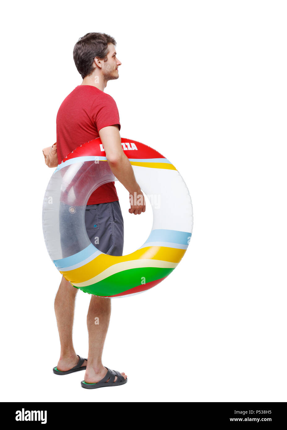 Vista posteriore di un uomo in pantaloncini corti con un cerchio gonfiabile. Il ragazzo sulla spiaggia. Vista posteriore di raccolta persone. vista posteriore di persona. Isolate su wh Foto Stock