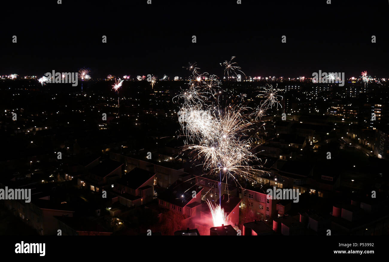 Vista Birdseye di esplodere i fuochi d'artificio in un quartiere olandese con un skline riempito con fuochi d'artificio in background. Foto Stock