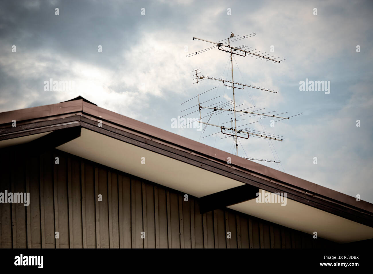 Close up classica vecchia antenna TV sul tetto della casa oltre il cielo  nuvoloso Foto stock - Alamy