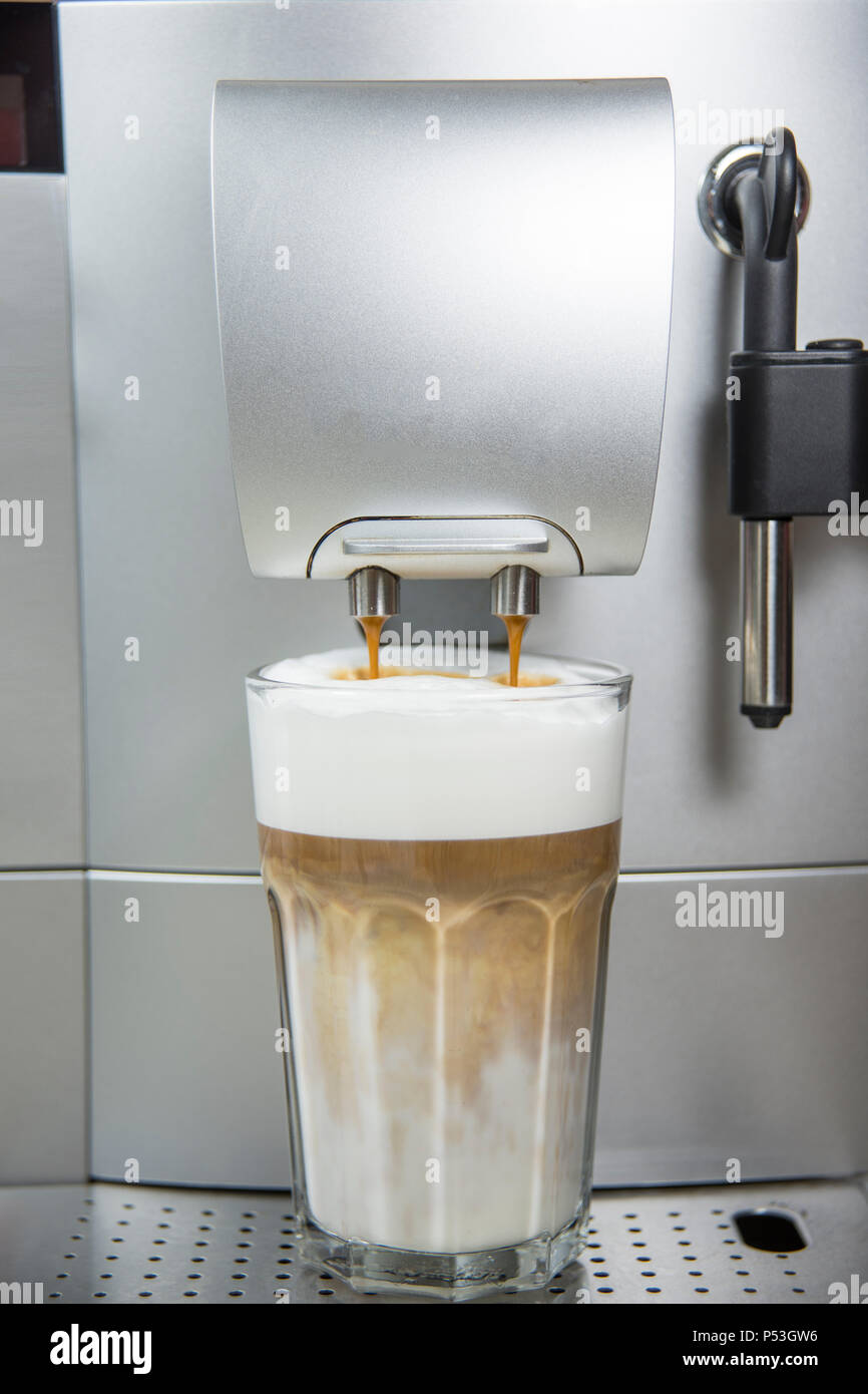 Una macchina per il caffè fa un latte macciato, rende il caffè espresso o in schiuma di latte Foto Stock