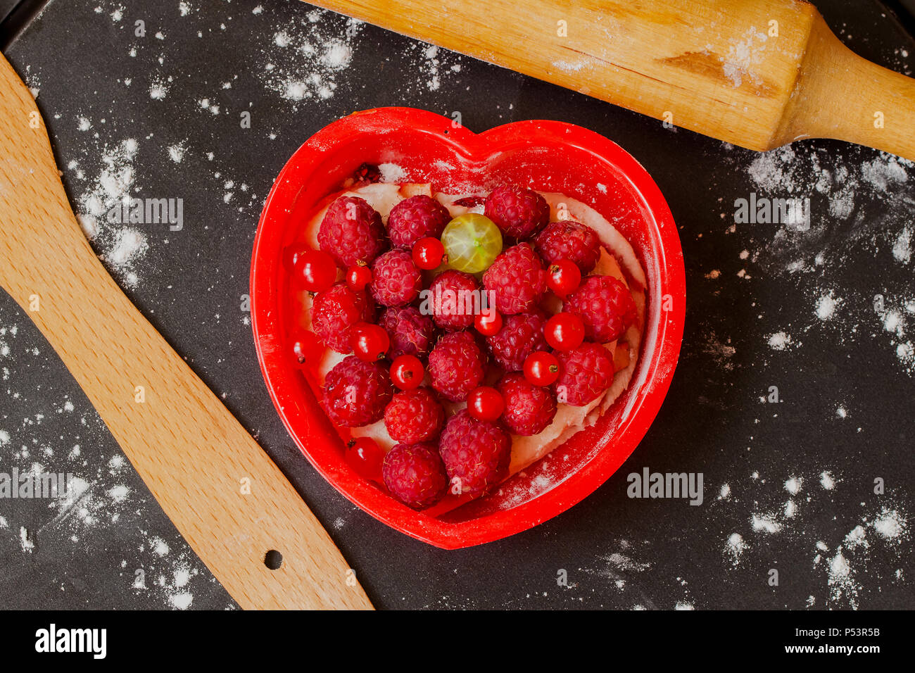 Forma di cuore torta con lamponi freschi Foto Stock