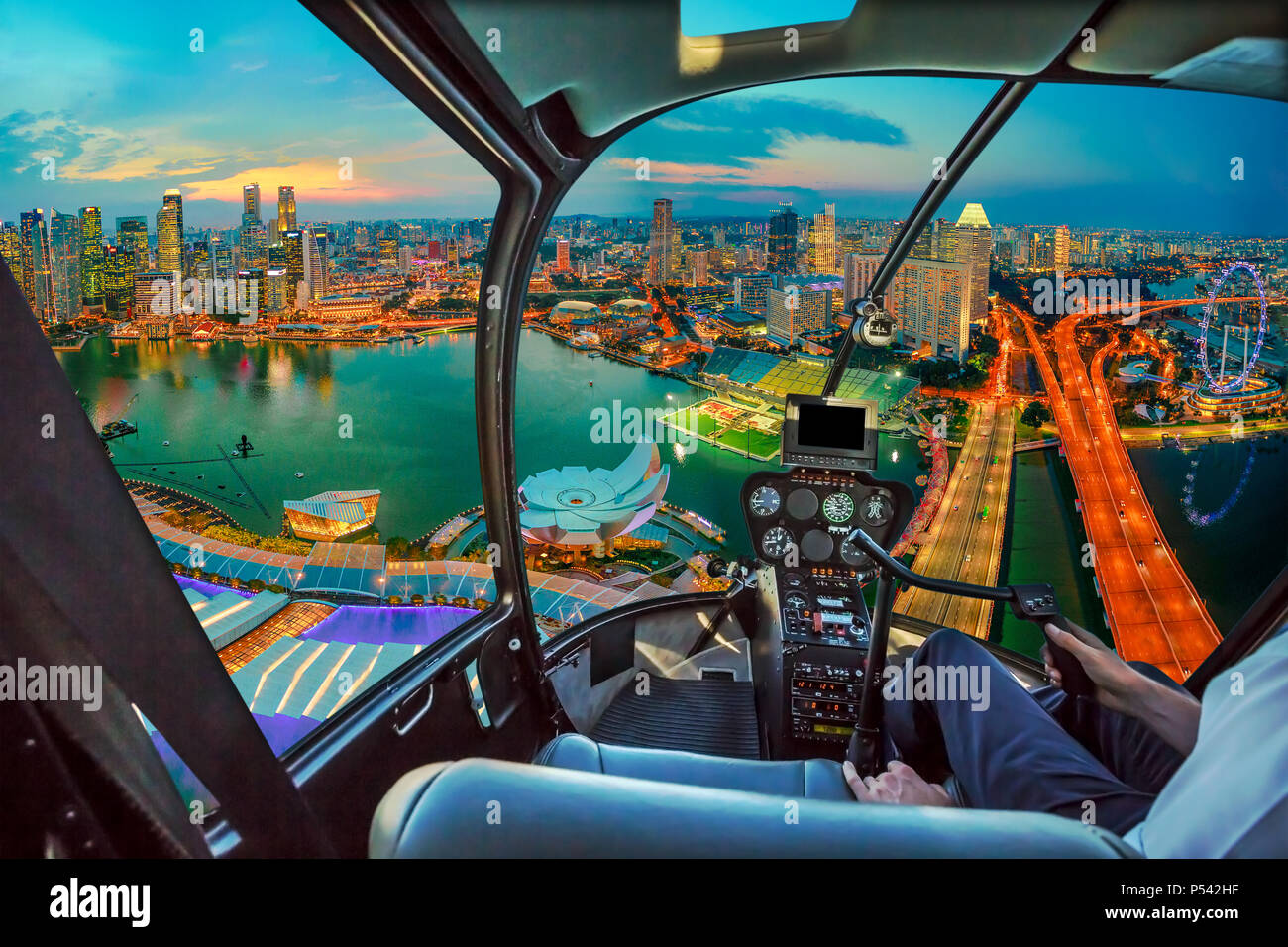 Elicottero pozzetto interno su twilight panorama di Singapore marina bay con illuminata grattacieli del quartiere finanziario del centro cittadino di Citta'. Singapore cityscape vista aerea. Foto Stock