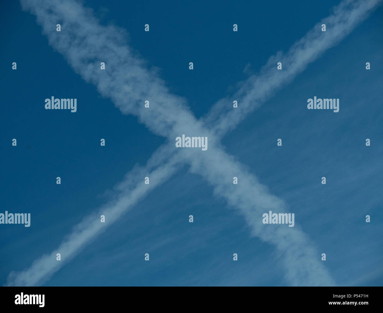 Una croce formata su un cielo blu da due attraversare sentieri a getto Foto Stock