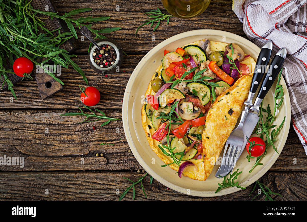 Frittata con pomodori, zucchine e funghi. La frittata prima colazione. Cibo sano. Vista dall'alto. Lay piatto Foto Stock