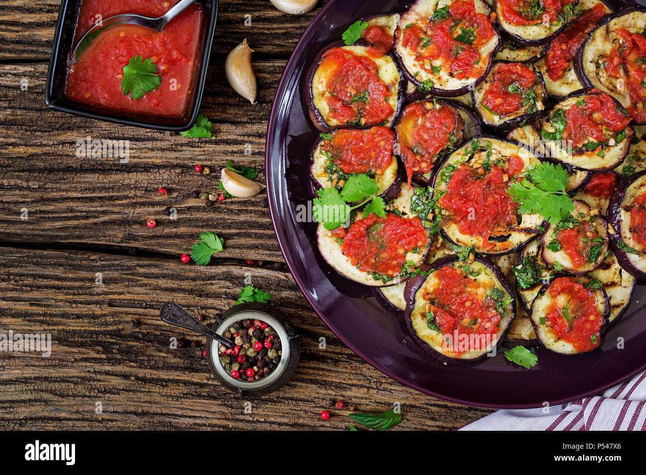 Melanzane alla griglia con salsa di pomodoro, aglio, coriandolo e menta.  Cibo vegan. Melanzane grigliate. Vista dall'alto. Lay piatto Foto stock -  Alamy