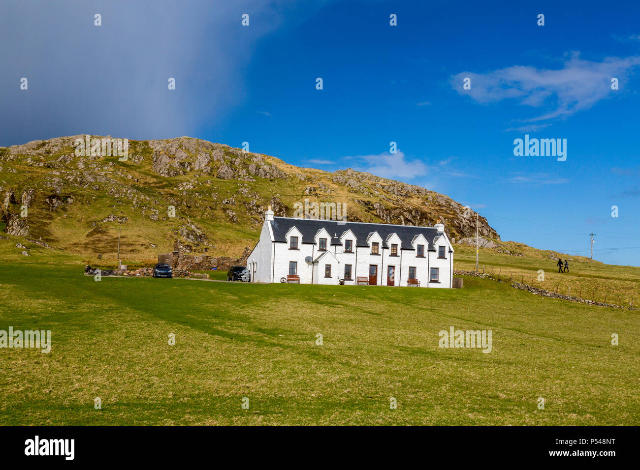 Un isolato cottage imbiancate ai piedi di Dun I (101m) è il punto più alto dell'isola delle Ebridi di Iona, Argyll and Bute, Scotland, Regno Unito Foto Stock