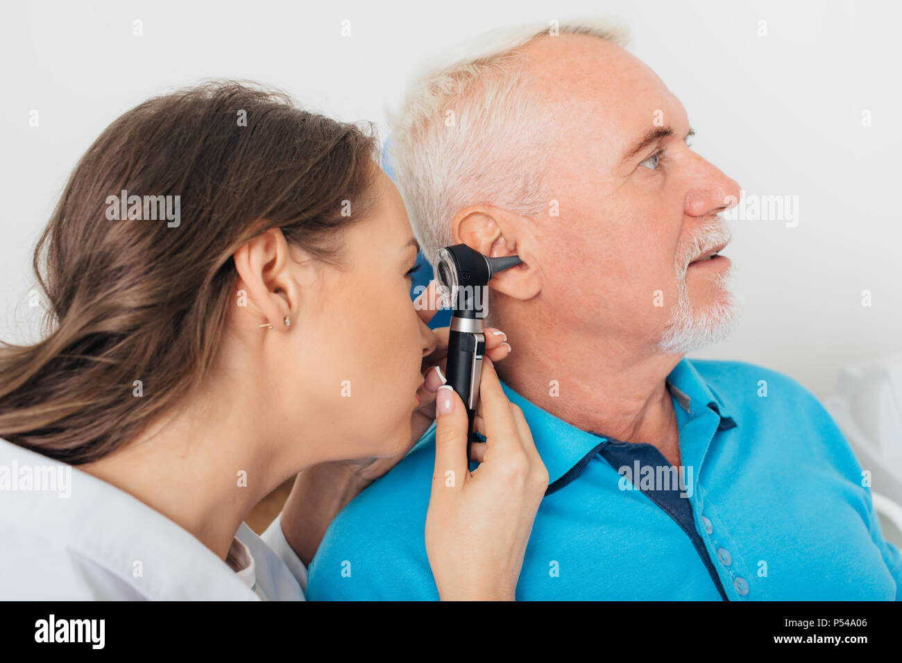 Esame medico senior uomo l orecchio Foto Stock