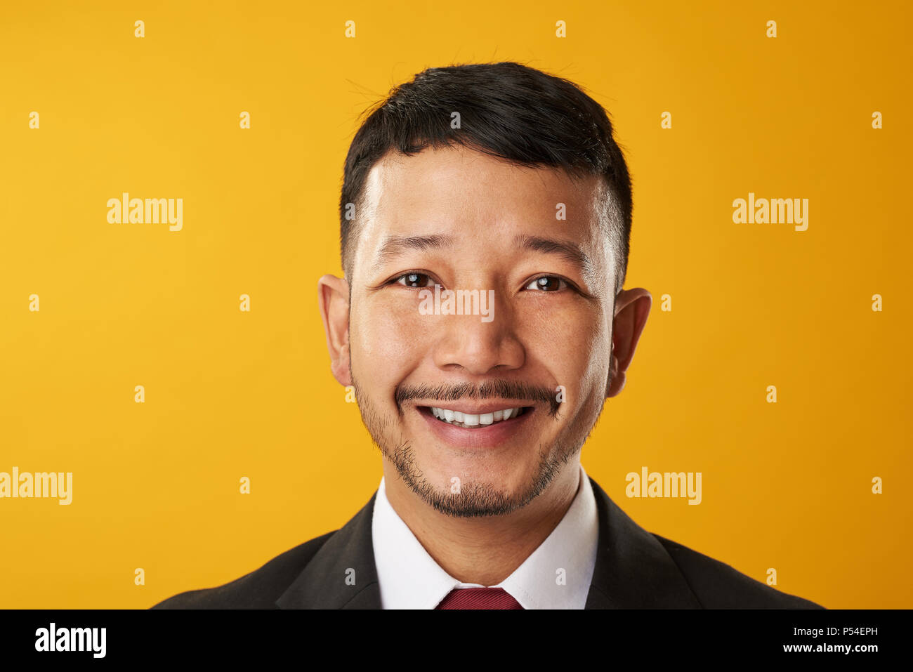 Sorridenti asian business man headshot ritratto isolato su sfondo giallo Foto Stock