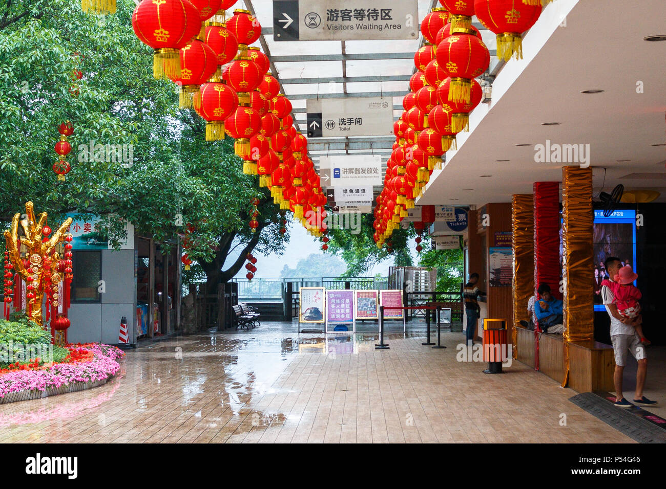 Una piattaforma esterna con padiglioni commerciali vicino all'ingresso della Grotta del Flauto di Canna, che si trova nella città cinese di Guilin. Foto Stock