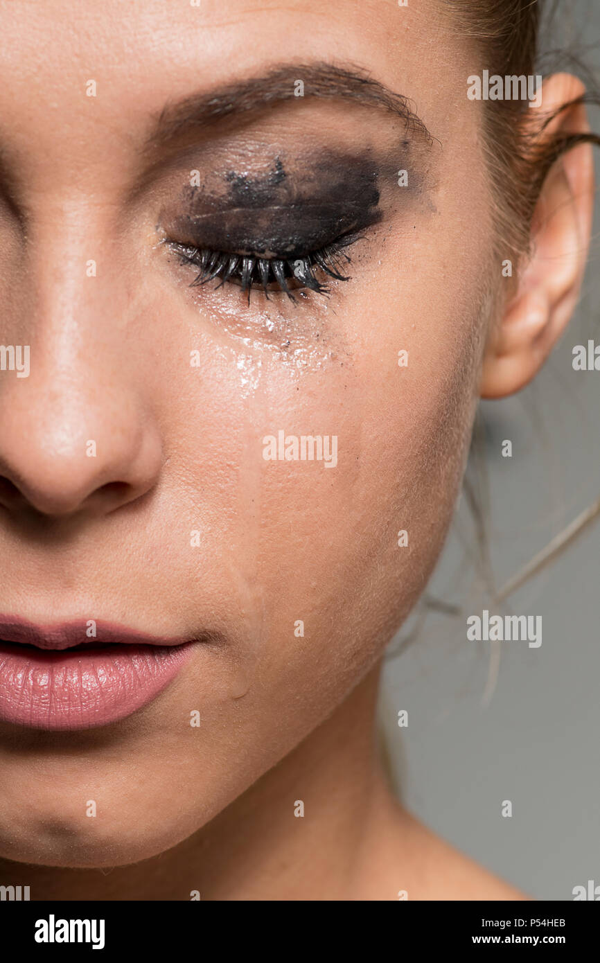 Triste RAGAZZA CHE PIANGE gli occhi chiusi con sbavature di make-up close-up shot Foto Stock