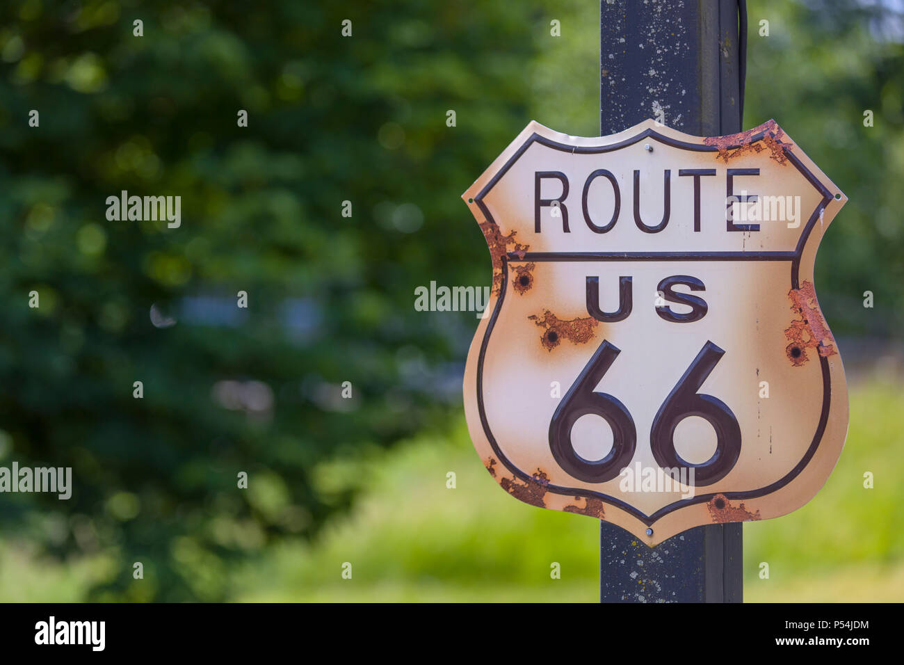 Rustico cercando la US Route 66 cartello o segnaletica con fori di proiettile vicino fino Foto Stock