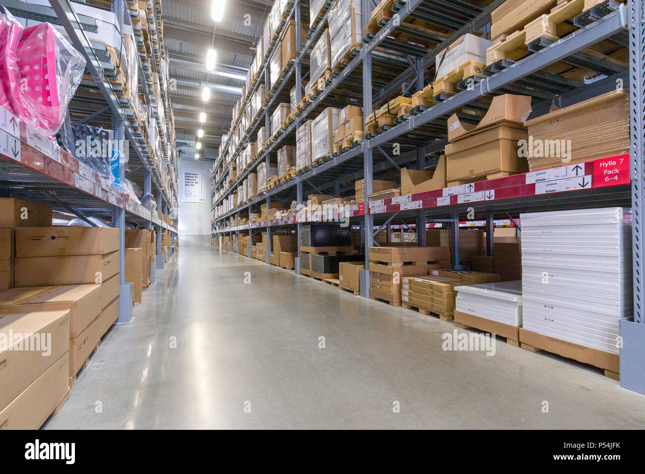 Vista interna delle navate laterali in un grande magazzino impilati con le scatole di cartone Foto Stock