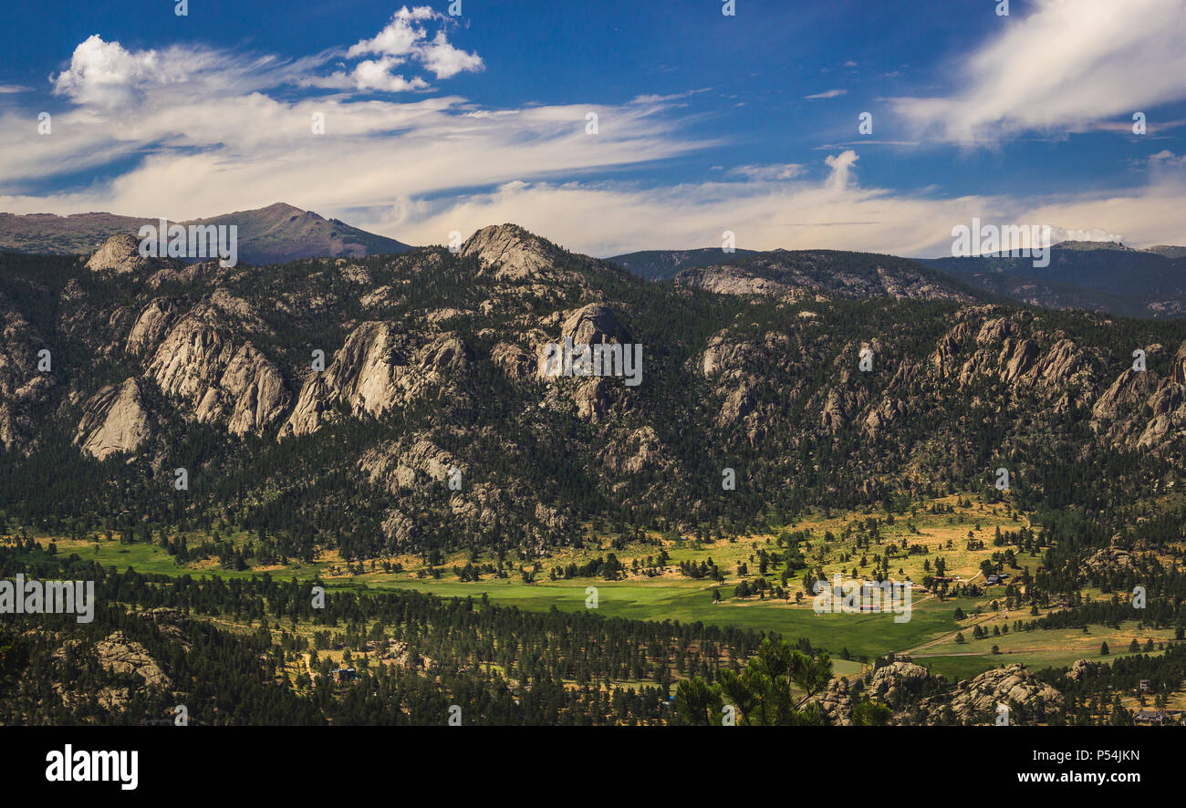 Panoramica valle e cime innevate sotto un cielo blu con nuvole in Estes Park, Colorado, vicino al Parco Nazionale delle Montagne Rocciose. Vista aerea da summ Foto Stock