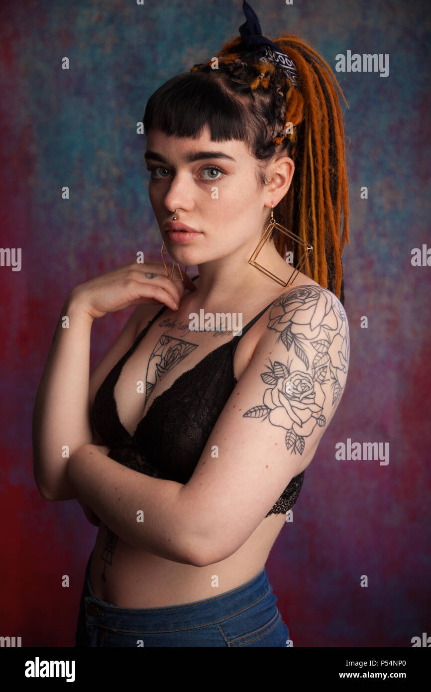 Alternativa alla ricerca giovane donna con dreadlocks e tatuaggi, Fife Scozia. Foto Stock