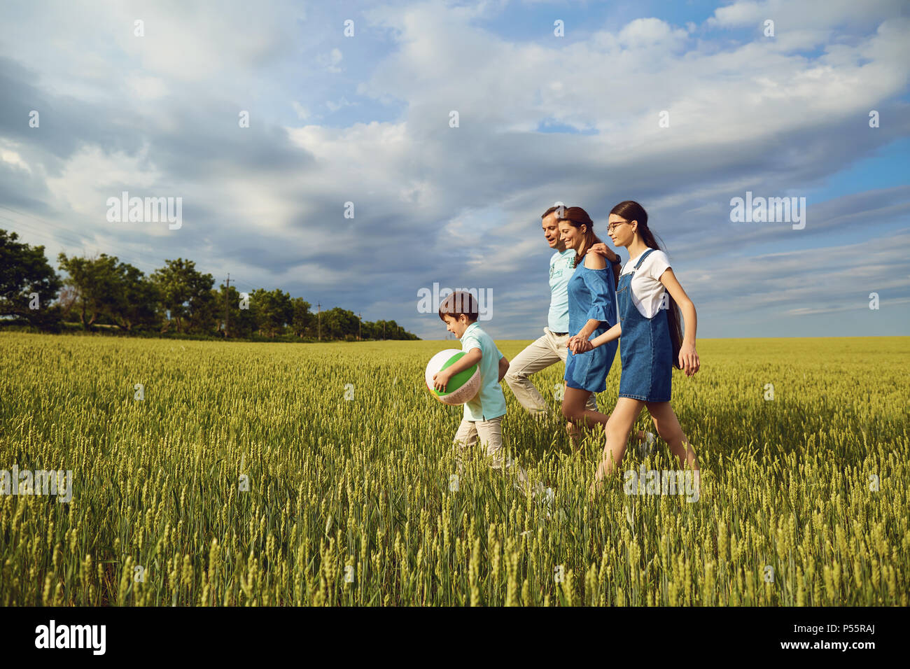 La famiglia felice a piedi in campo estivo Foto Stock