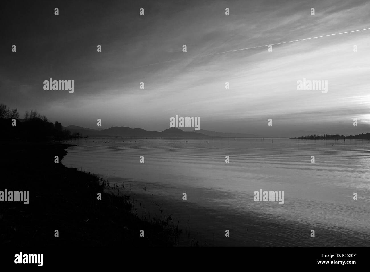 Bellissima vista del lago Trasimeno (Umbria, Italia), con colline e cielo riflettendo sull'acqua Foto Stock